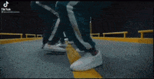 a group of people are standing next to each other on a street wearing white sneakers .