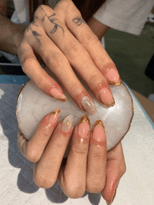 a woman 's hand with a tattoo on her finger that says ' a '