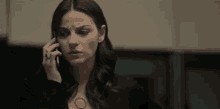 a woman is talking on a cell phone in an office .