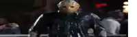 a man in a jason voorhees mask is standing in a dark room .