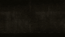 a man is standing in a dark room with a spotlight shining on him .