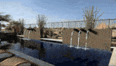 a fence surrounds a swimming pool with a fountain in the middle of it