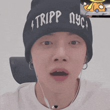 a person wearing a beanie that says tripp nyc on it