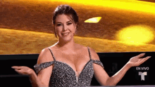 a woman in a very revealing dress is sitting in front of a tv screen that says en vivo .