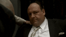 a man in a suit and tie has a hand on his neck