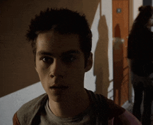 a close up of a young man 's face with a shadow on the wall