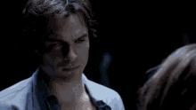 a woman in a plaid shirt looks at a man in a blue shirt