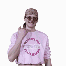 a man wearing sunglasses and a pink shirt that says nationally unavailable