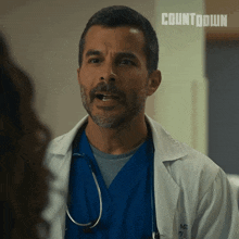 a man with a beard and a stethoscope is wearing a lab coat that says md