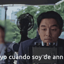 a man sitting in front of a camera with yo cuando soy de ann written in white