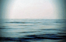 a large body of water with waves and a white sky