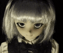 a close up of a doll with a bow tie