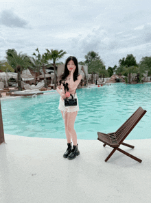 a woman standing in front of a large pool