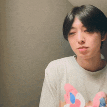 a young man wearing a white shirt with a pink and blue bunny on it