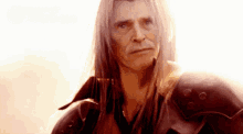 a man with long white hair is wearing a red armor .