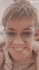 a boy wearing glasses and a white shirt is smiling in a photo taken by the faceapp app