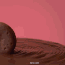 a person is holding a chocolate cookie on top of a chocolate cake