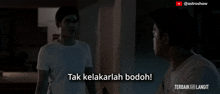 two men are standing next to each other in the dark and one of them says tak kelakarlah bodoh