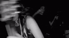 a black and white photo of a woman dancing in a nightclub .