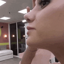 a close up of a woman 's face with her hand on her chin