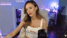 a woman wearing a white tank top that says baby
