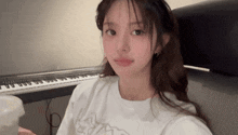 a girl is sitting in front of a keyboard and a cup of coffee .