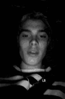 a black and white photo of a young man with a pencil in his mouth .
