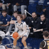 a basketball player with the number 3 on his jersey is holding an orange ball