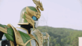 a man in a green and gold robot costume with a dragon on his head .
