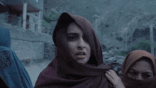 a woman wearing a scarf around her head looks very angry