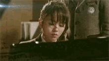 a person is playing a piano on the floor with their hands on the keys .