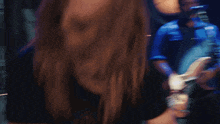 a man with long hair is playing a guitar and the word whiz is visible in the background