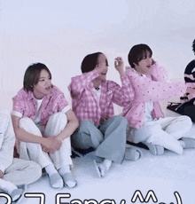 a group of people sitting on the floor with the word fan on the bottom left