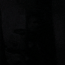 a woman is standing in front of a mirror in a dark room .