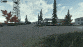 a screenshot of a video game with a tower and trees