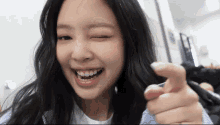 a close up of a woman smiling and pointing