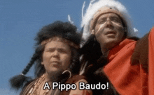 two men dressed as native americans are standing next to each other and talking .