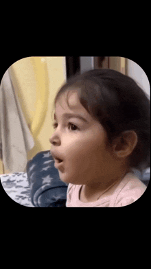 a little girl is making a surprised face with her mouth open .