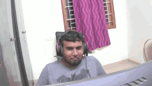 a man wearing headphones sits in front of a msi computer
