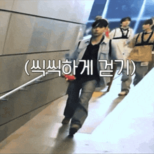 a group of people are walking down a staircase with chinese writing on the bottom