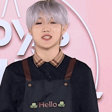 a boy wearing an apron that says hello on it