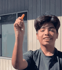 a young man is holding a carrot in his hand