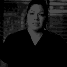 a black and white photo of a woman in a black scrub top .