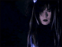 a woman with long dark hair is wearing a black sweater