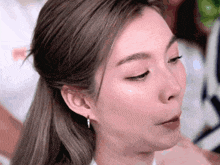 a close up of a woman 's face with a ponytail