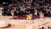 a basketball game is being played in front of a crowd and a sign that says get the app