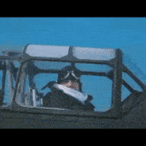 a man wearing a helmet and goggles is sitting in a plane cockpit