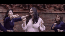 a group of women are dancing in front of a brick building