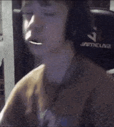 a man wearing headphones is sitting in a gamelab chair with his eyes closed .