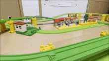 a toy train set with houses and trees on the tracks